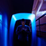 Closeup of a man using mobile phone in the dark with blue long e